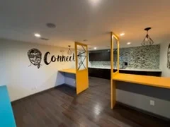 Commercial office interior with yellow steel framing, concrete floors, and custom wall signage