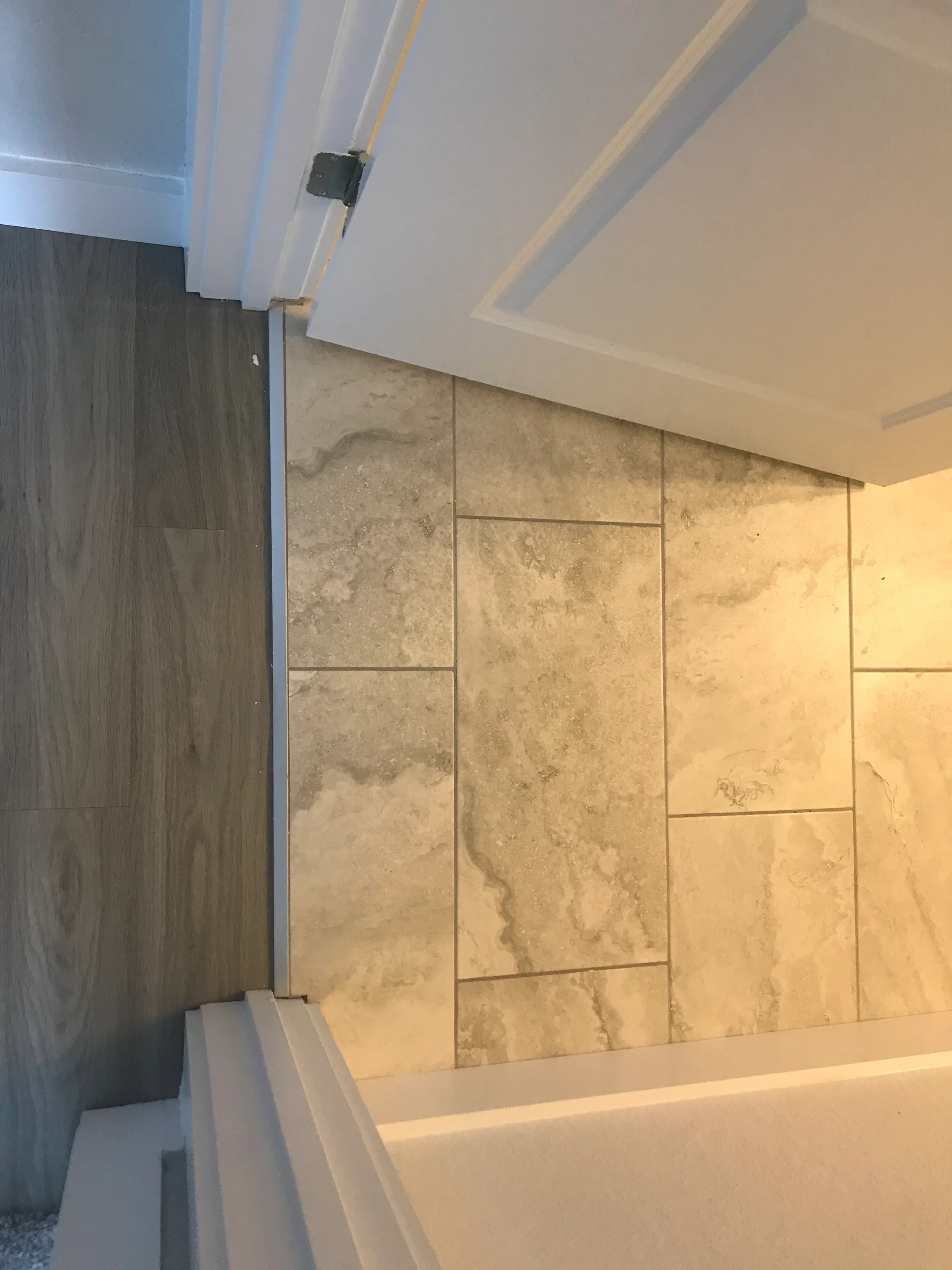 Bathroom shower wall with large travertine tiles and modern ceiling lighting
