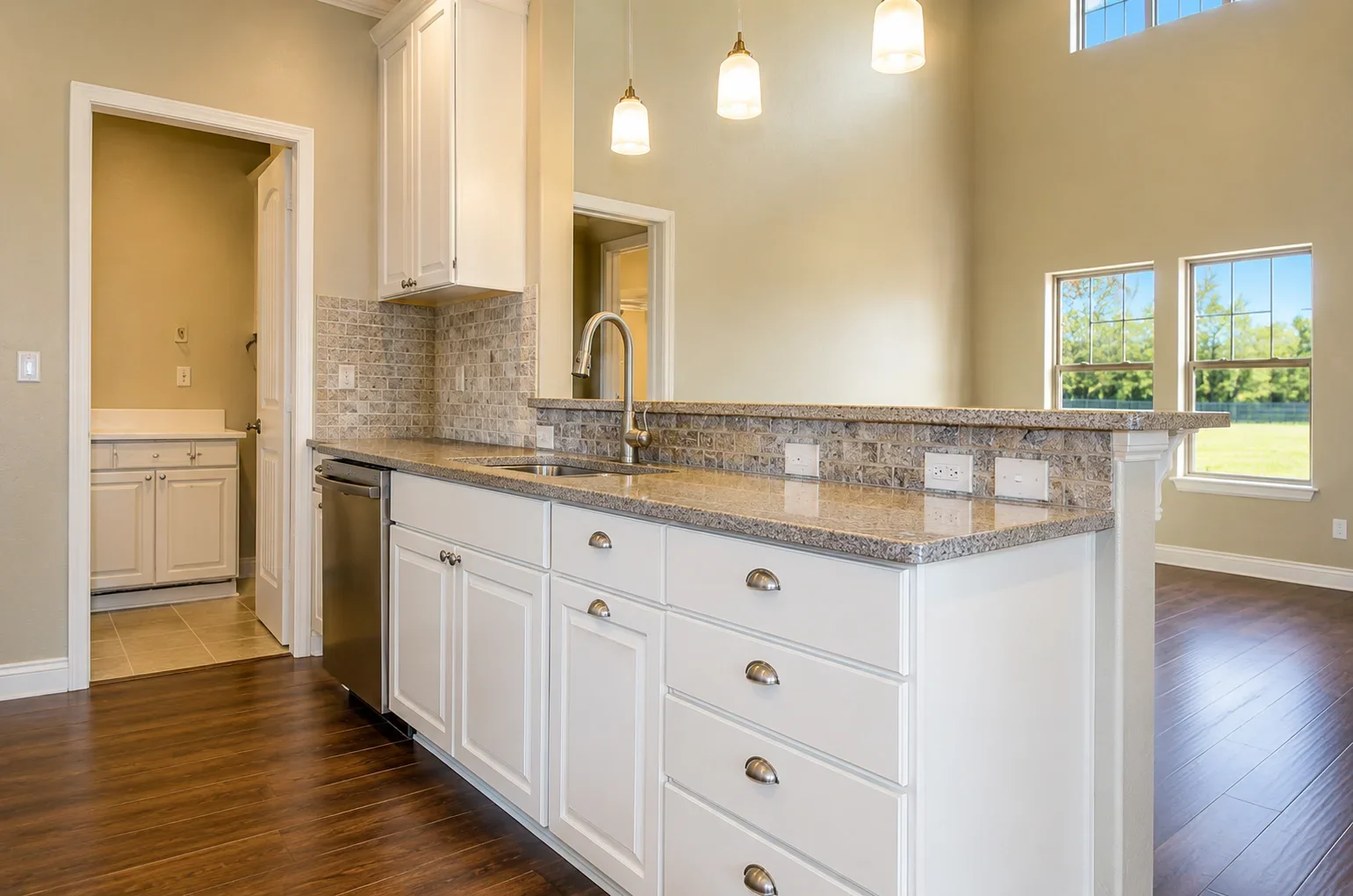 Modern kitchen with white cabinets, granite counters, island, and stainless steel appliances