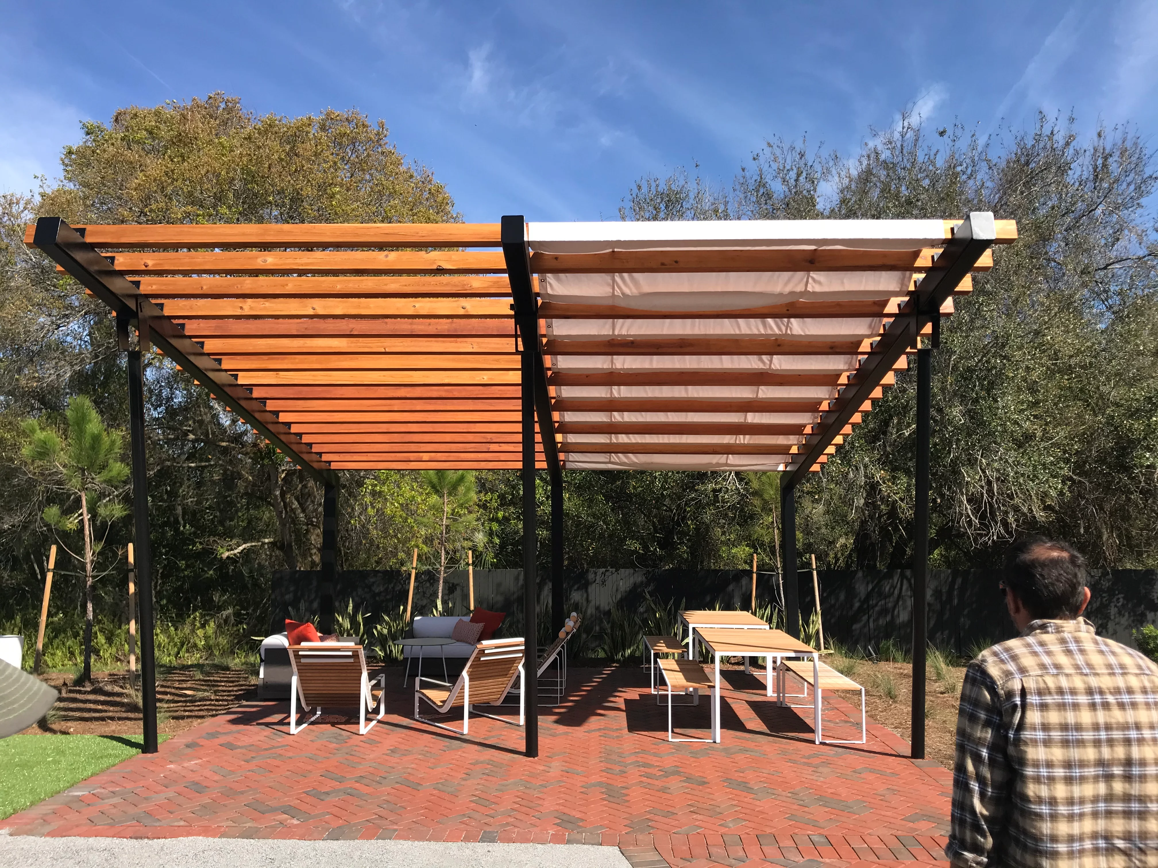 Modern pergola with retractable shade over brick patio with lounge seating