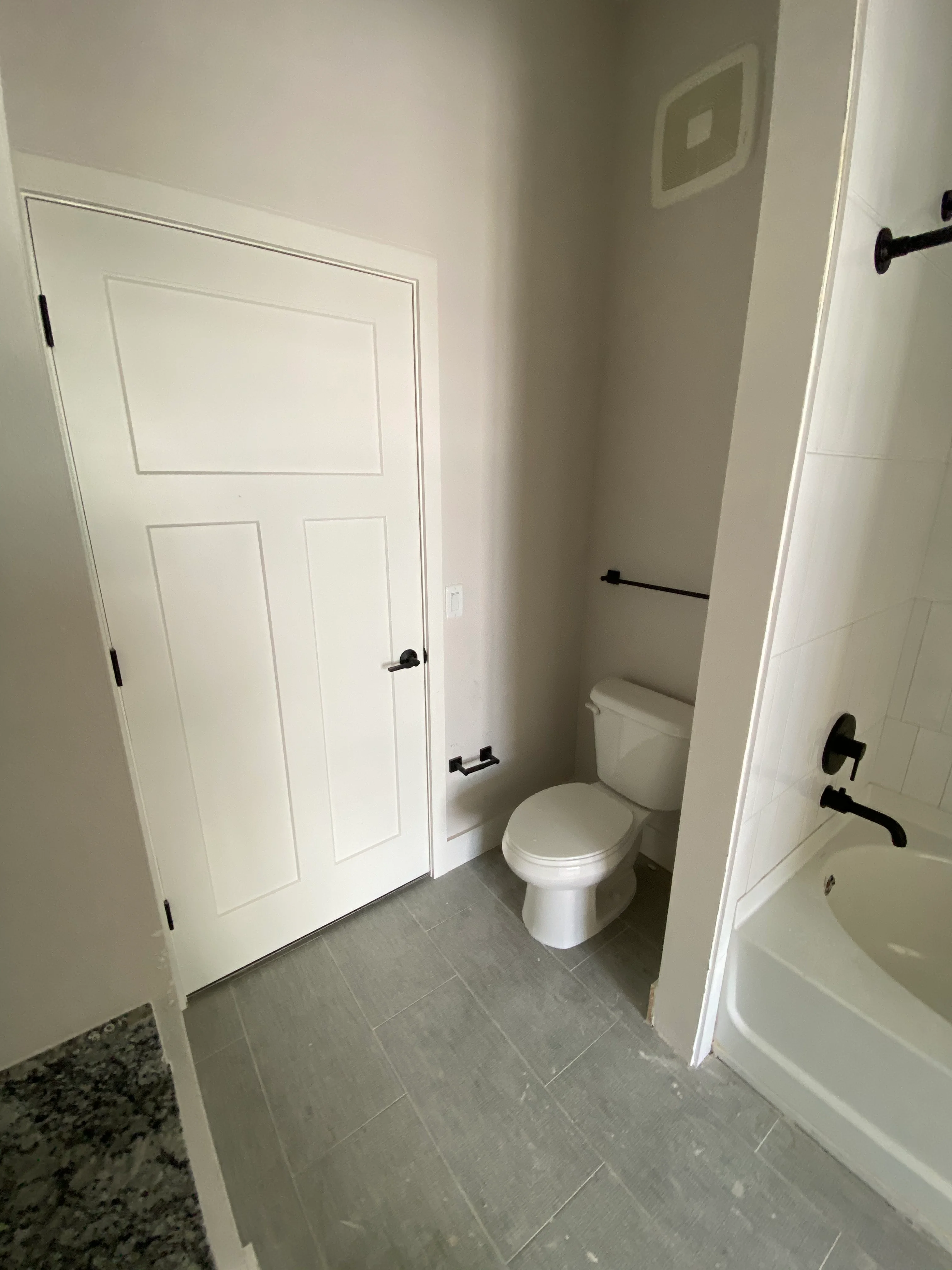 Newly remodeled bathroom with gray tile floor, white walls, and modern fixtures