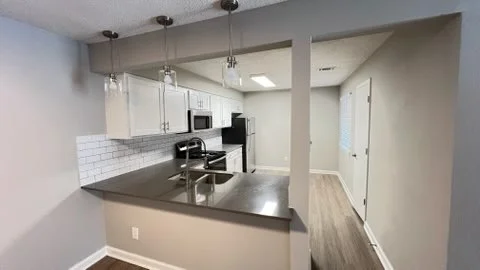 Modern kitchen with white subway tile, stainless steel appliances, and dark island countertop