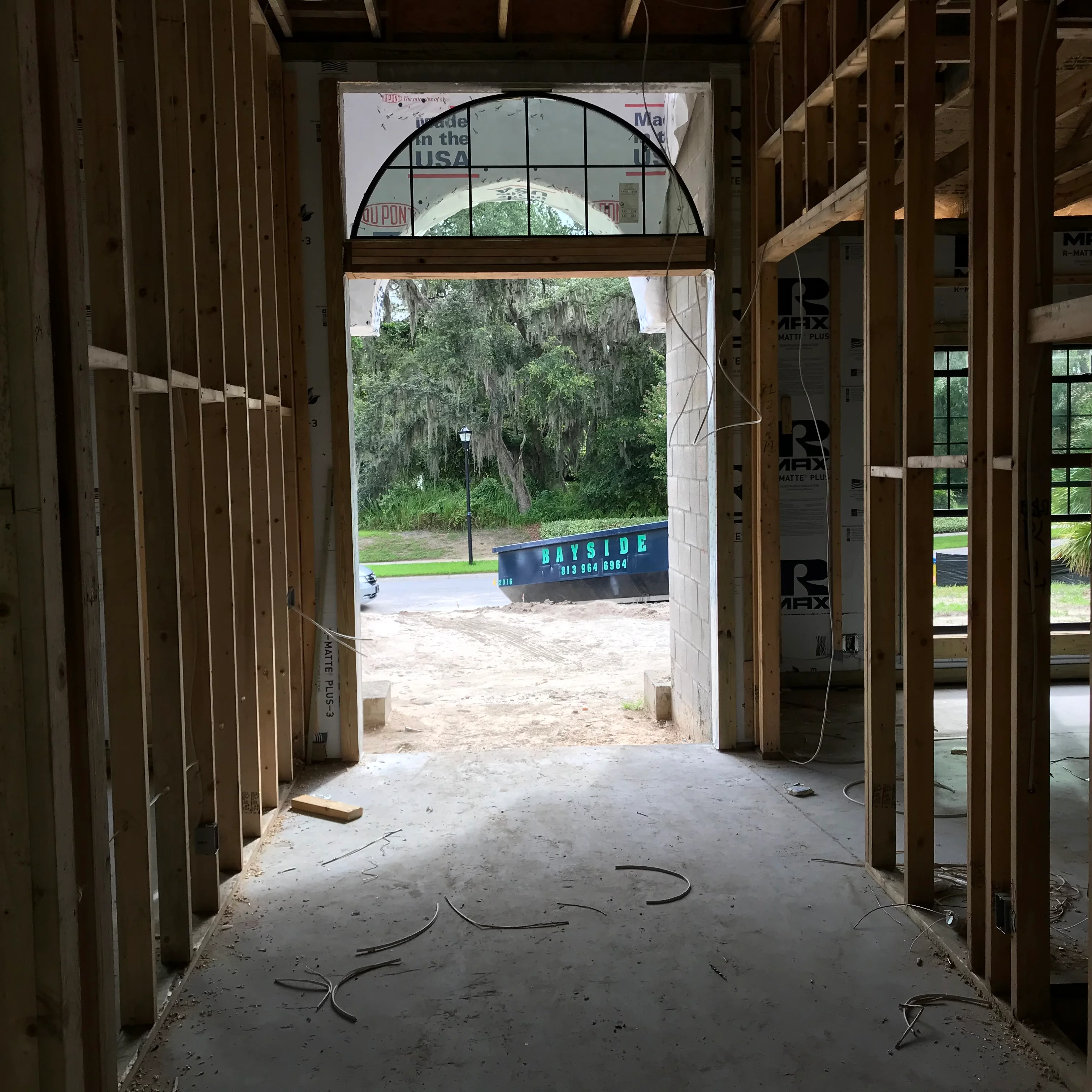 Interior framing with arched transom window overlooking landscaped exterior
