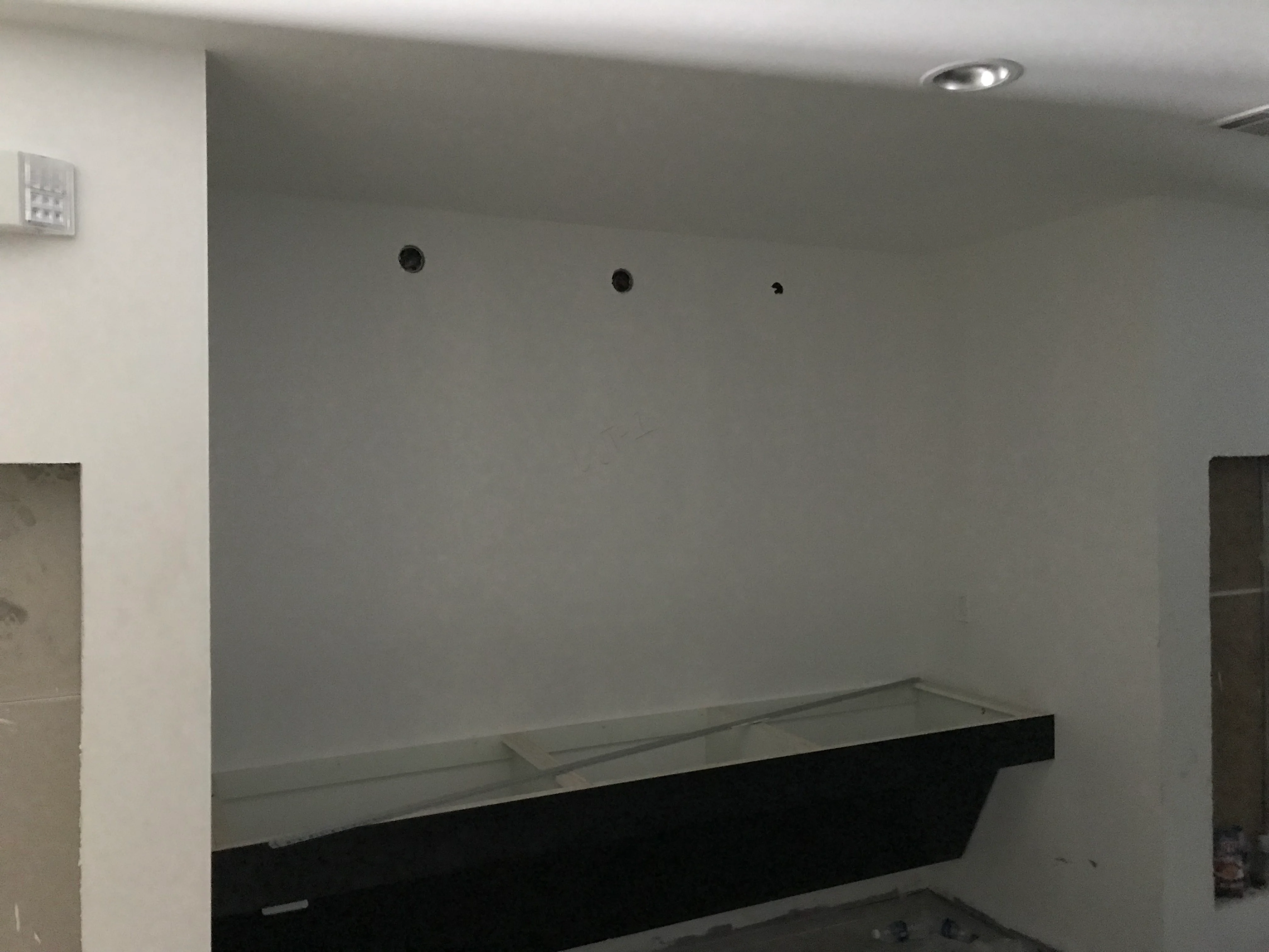 Freshly installed drywall with electrical boxes on interior wall during construction phase