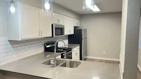Modern kitchen with white cabinets, stainless steel appliances, and quartz countertops