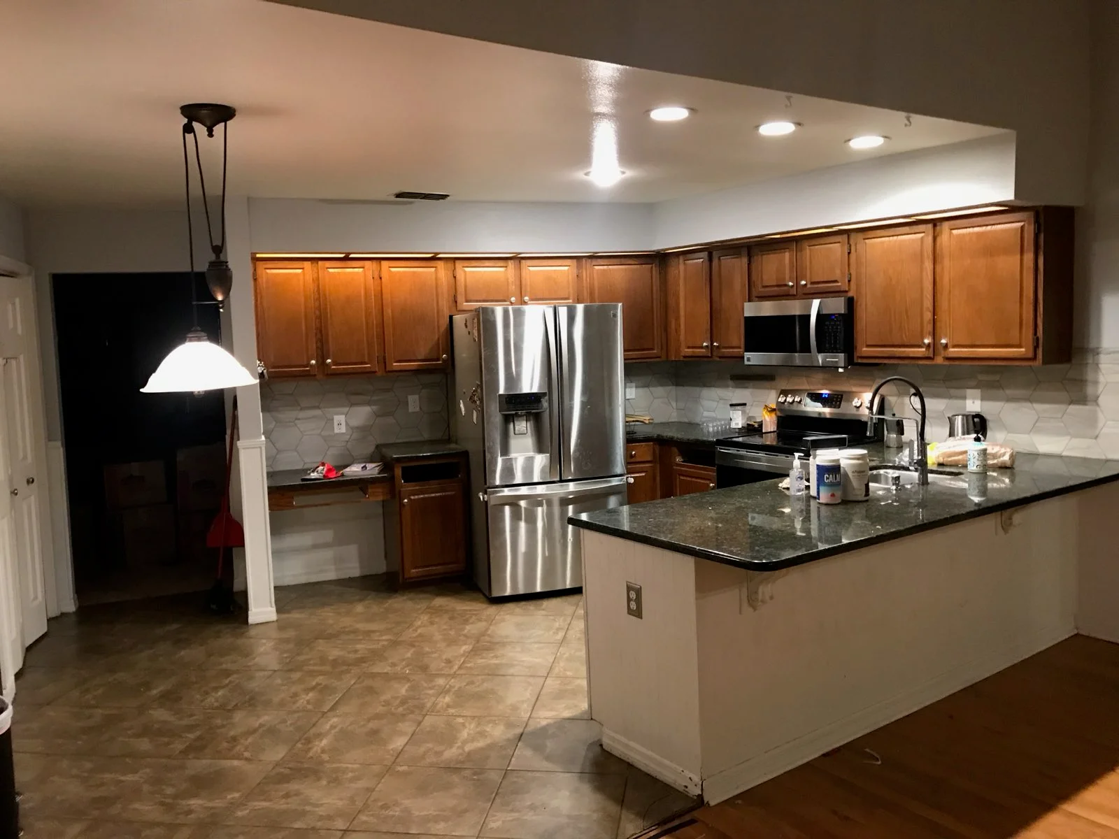 Modern kitchen with wood cabinets, granite counters, island, and stainless steel appliances