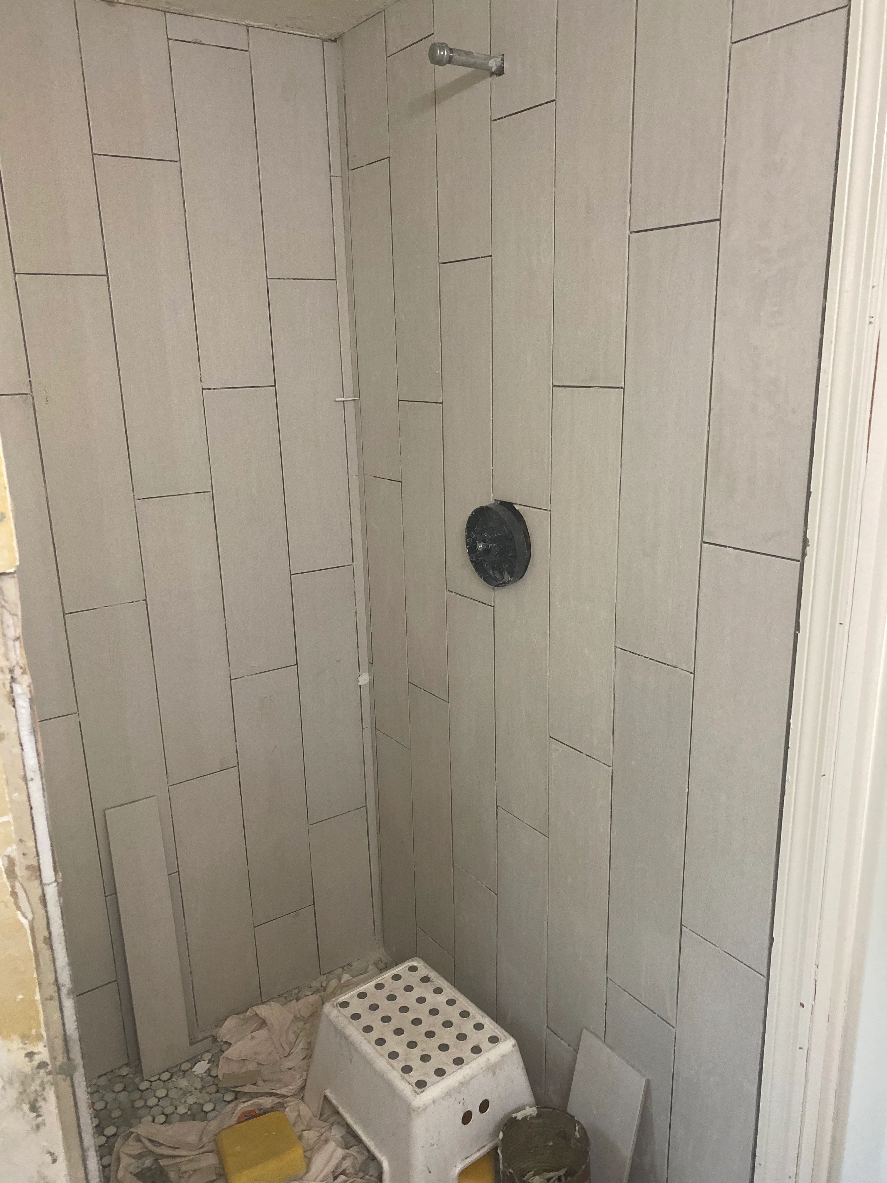 Newly tiled shower enclosure with vertical subway tiles and modern fixtures